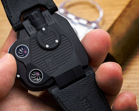 Close view of URWERK UR-110 ST steel ribbed bezel highlighting arrow shaped hour torpedoes and vertical minute scale.